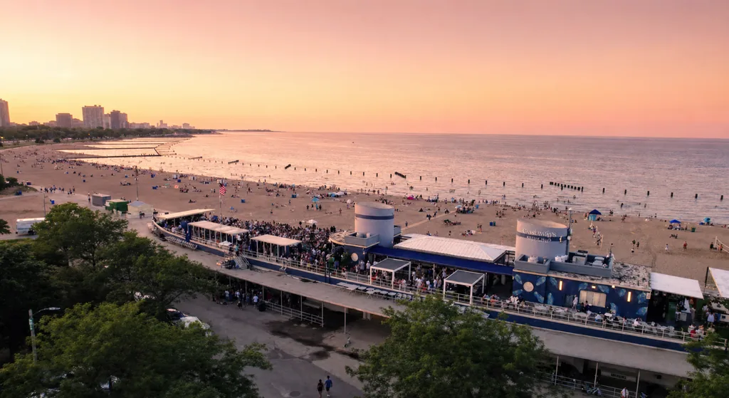 Castaways Beach Club beside North Avenue Beach, with Lake Michigan and the Chicago skyline at sunset